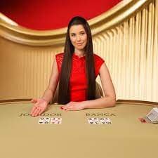 Dealer live casino membuka kartu Baccarat di meja permainan